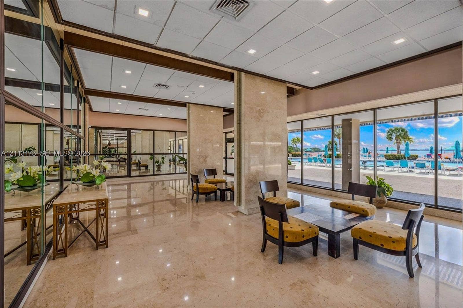 300 Bayview Drive, #1614, Sunny Isles Beach, FL 33160 Lobby featuring polished stone flooring, floor-to-ceiling glass walls, recessed lighting, and stone-clad pillars