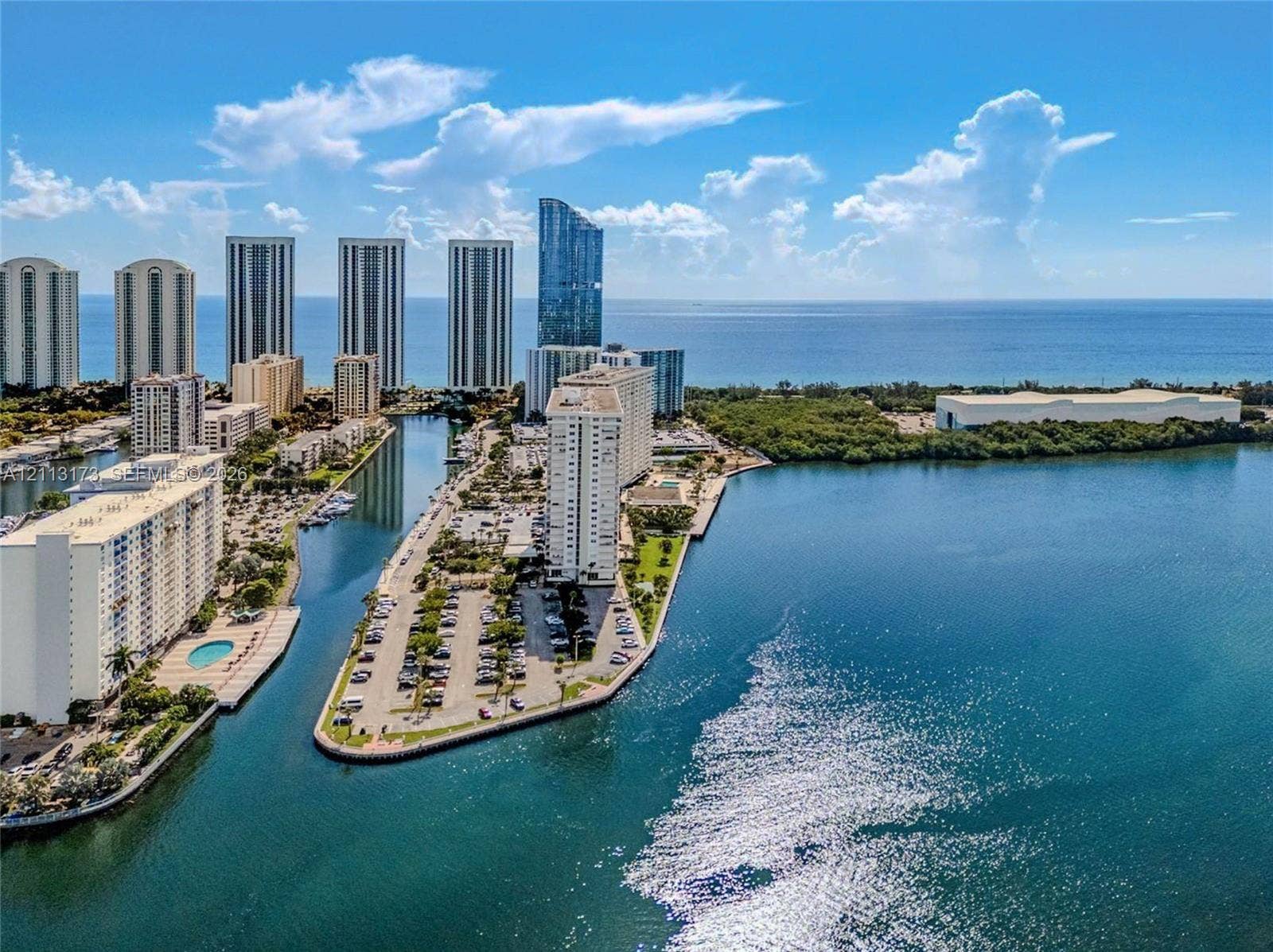 300 Bayview Drive, #1614, Sunny Isles Beach, FL 33160 Aerial perspective of coastal high-rise development featuring waterfront positioning, expansive water frontage, and surrounding urban skyline