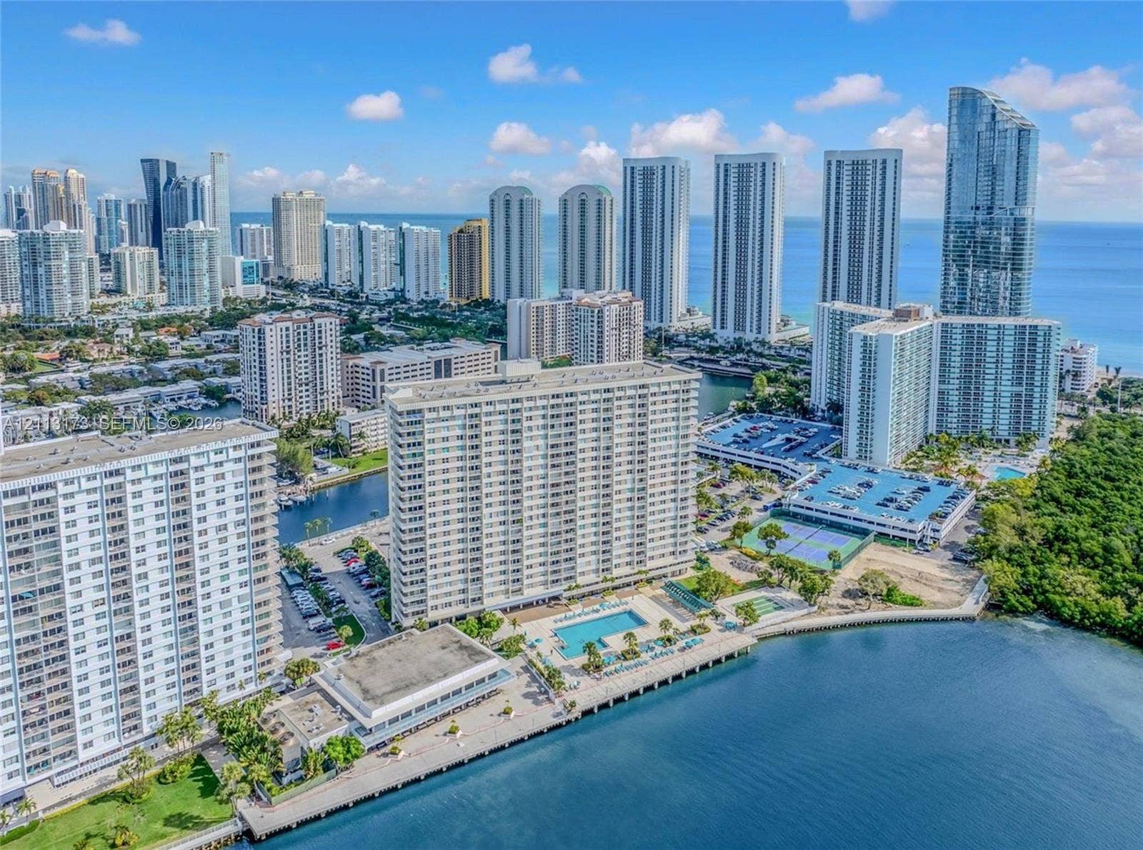 300 Bayview Drive, #1614, Sunny Isles Beach, FL 33160 Waterfront high-rise community featuring a swimming pool, tennis courts, paved parking, and direct water access