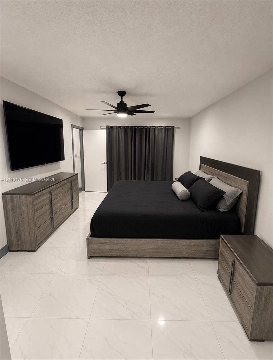 4391 NW 112th Avenue, Coral Springs, FL 33065 Large-format tile flooring, neutral wall tones, and a ceiling-mounted matte black fan
