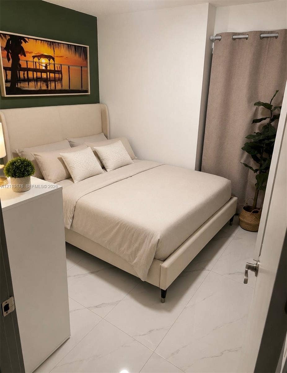 4391 NW 112th Avenue, Coral Springs, FL 33065 Large-format porcelain tile flooring with marble-pattern veining and an accent wall with a deep green finish