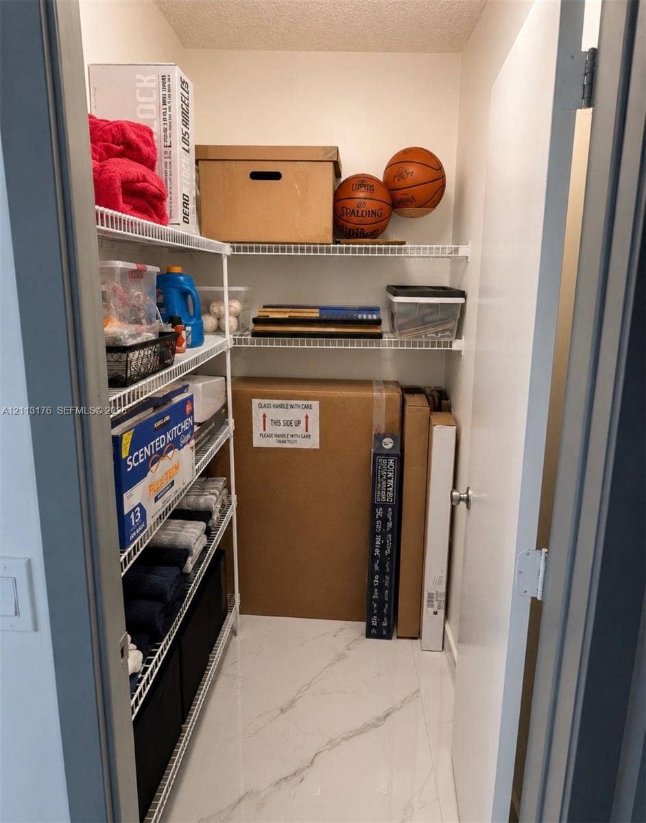 4391 NW 112th Avenue, Coral Springs, FL 33065 Storage closet featuring white wire shelving and stone-finish tile flooring