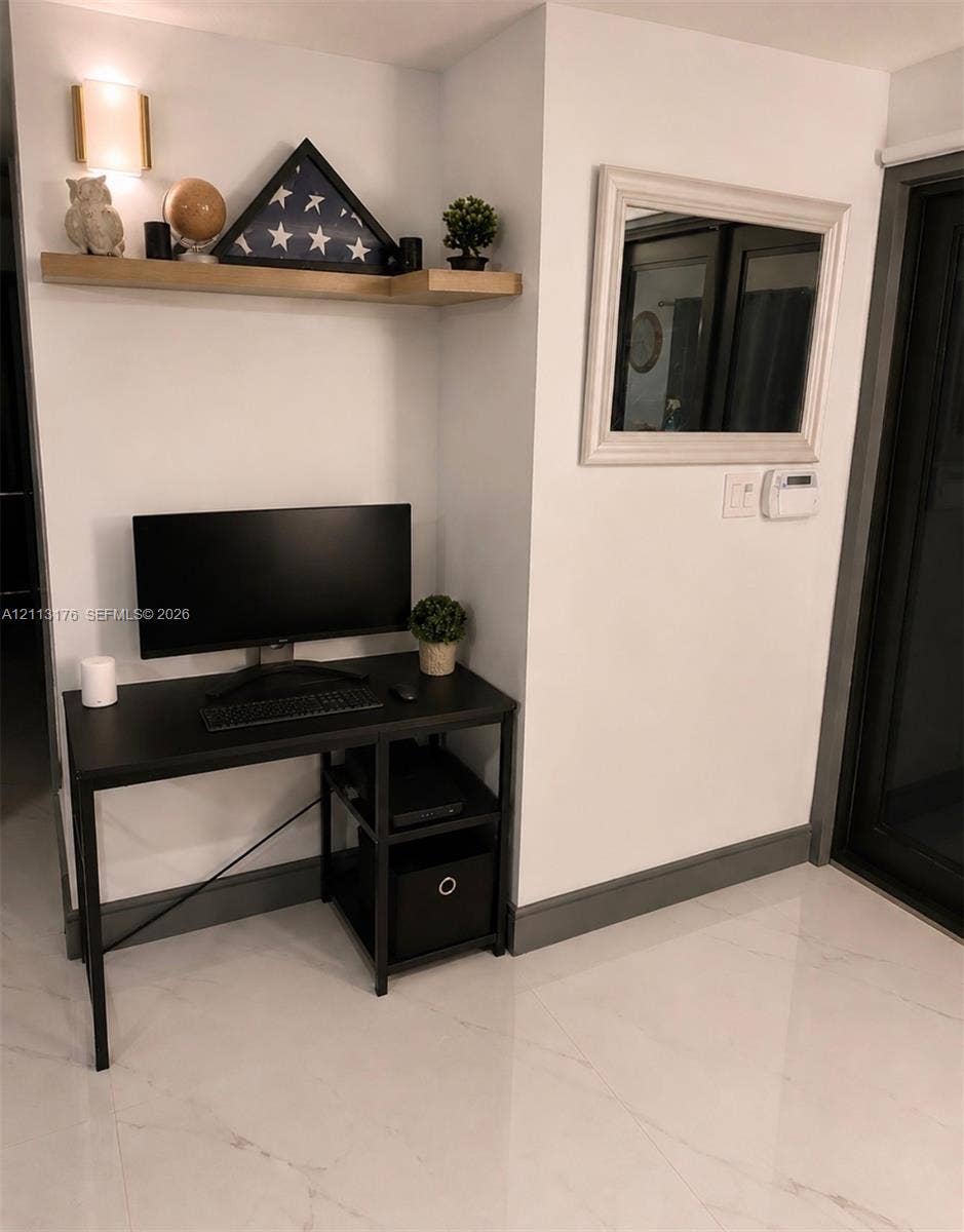 4391 NW 112th Avenue, Coral Springs, FL 33065 Built-in wall-mounted wood shelf with integrated sconce lighting, polished stone-finish flooring, and dark-toned trim