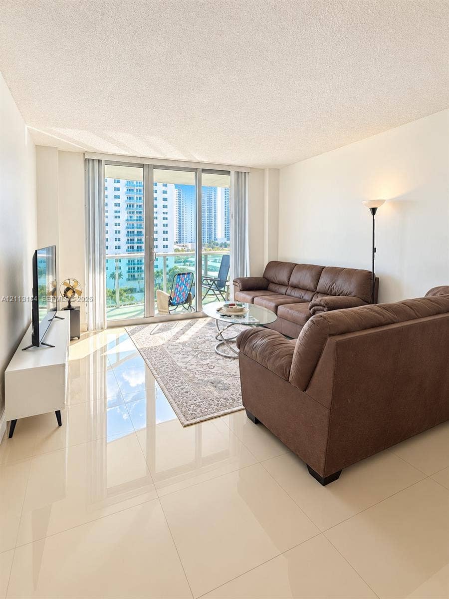 19380 Collins Avenue, #708, Sunny Isles Beach, Sunny Isles Beach, FL 33160 Living area featuring polished tile flooring, floor-to-ceiling windows, and access to a private balcony