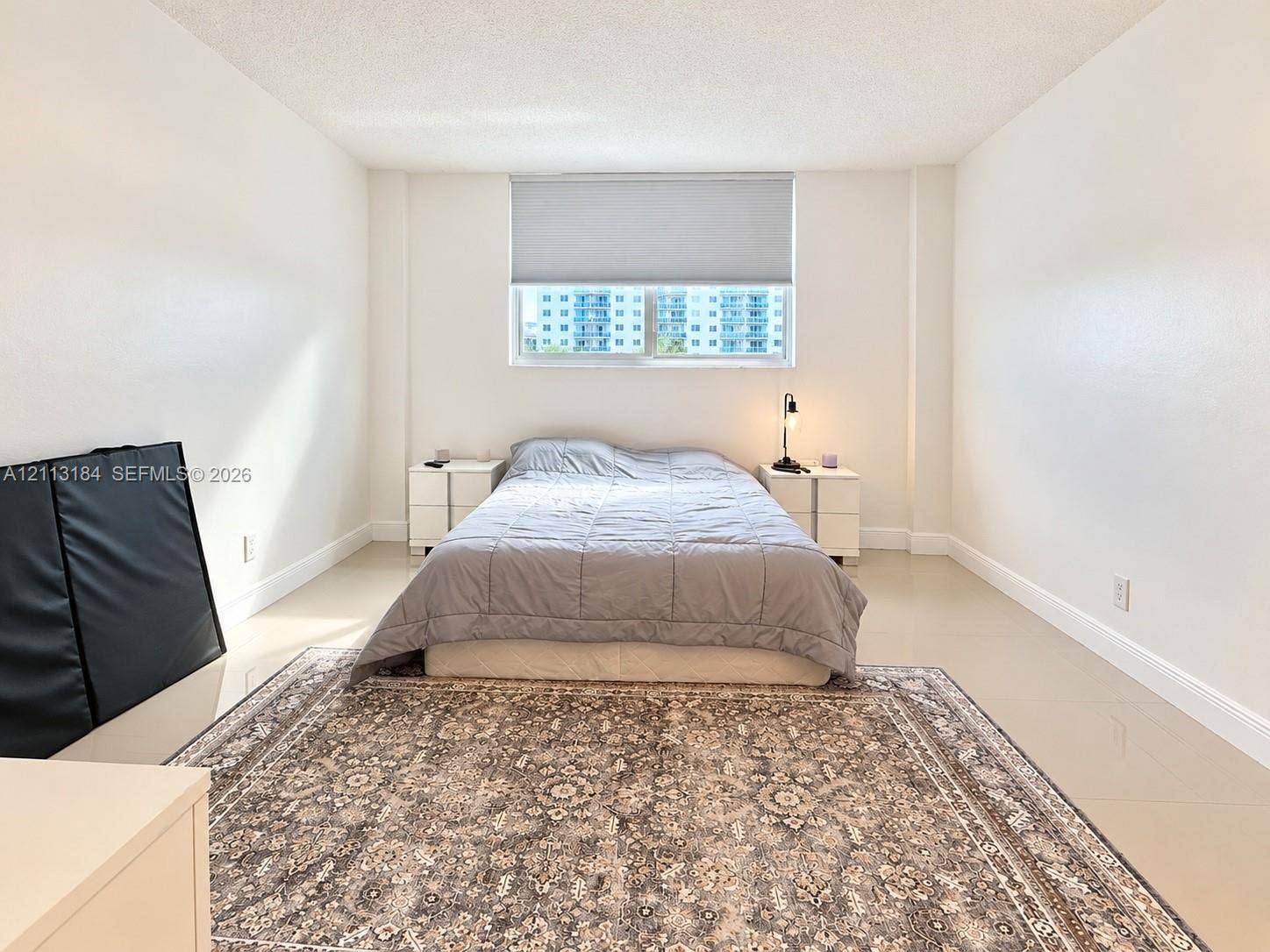 19380 Collins Avenue, #708, Sunny Isles Beach, Sunny Isles Beach, FL 33160 Neutral-toned interior featuring smooth wall finishes, large-format tile flooring, and a window with an integrated roller shade