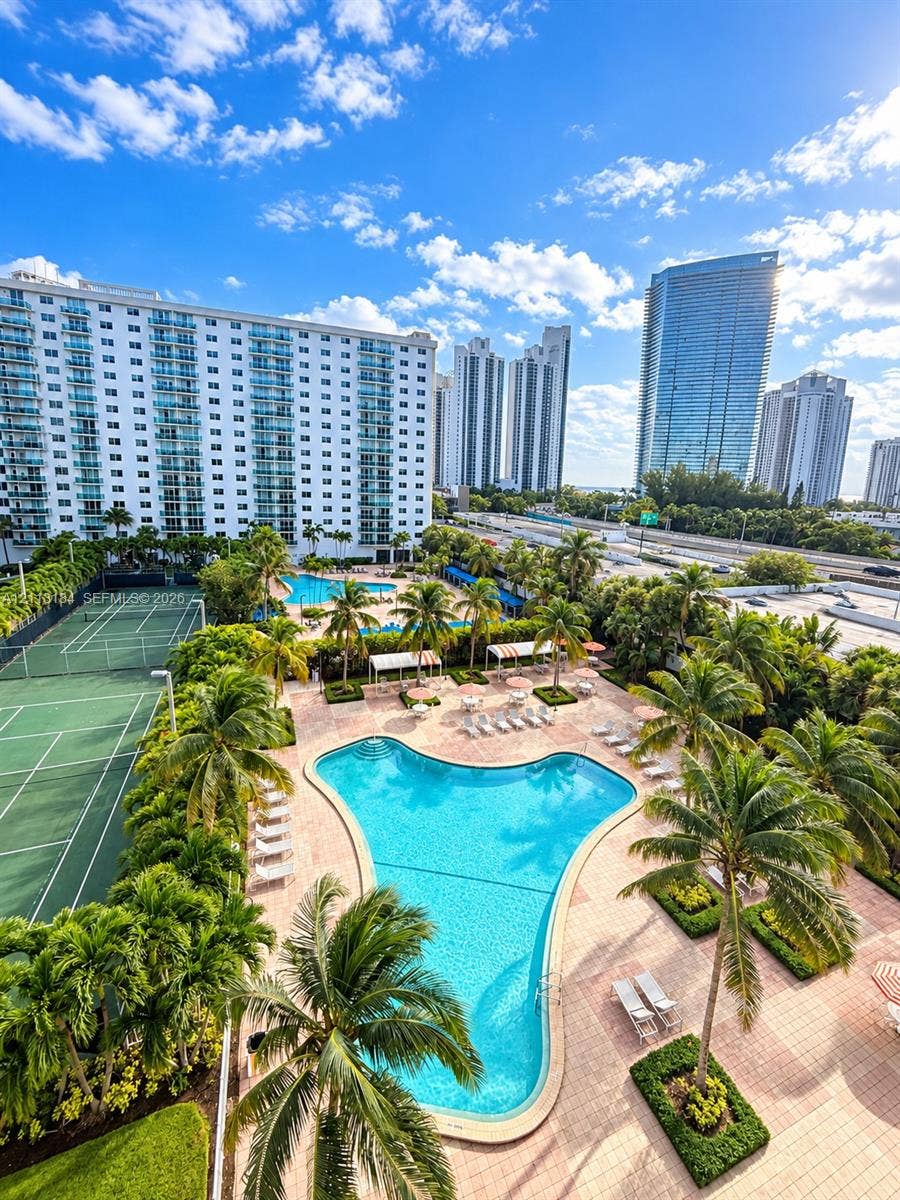 19380 Collins Avenue, #708, Sunny Isles Beach, Sunny Isles Beach, FL 33160 Community amenities including a swimming pool, tennis court, palm-lined hardscaping, and manicured landscaping