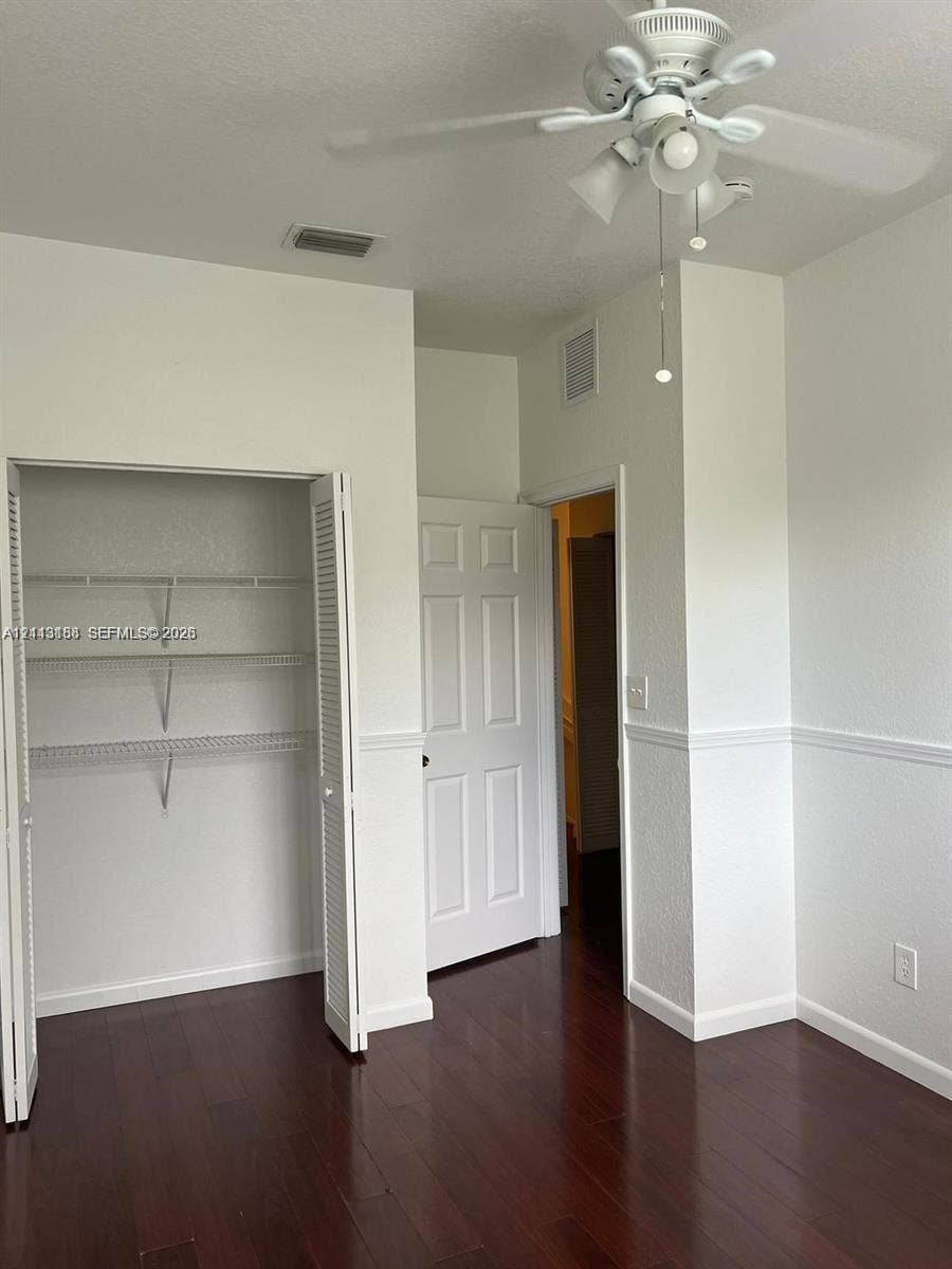 8706 NW 38th Drive, #2, Coral Springs, Coral Springs, FL 33065 Wood-finish flooring, ceiling fan with integrated lighting, reach-in closet with built-in wire shelving, and traditional chair rail molding