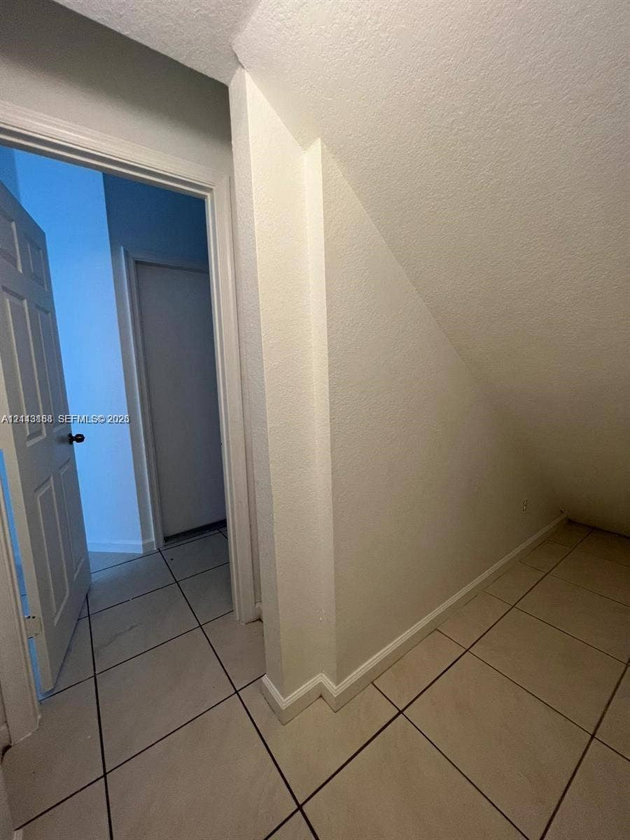 8706 NW 38th Drive, #2, Coral Springs, Coral Springs, FL 33065 Interior storage space featuring tile flooring, smooth walls, and a multi-panel door