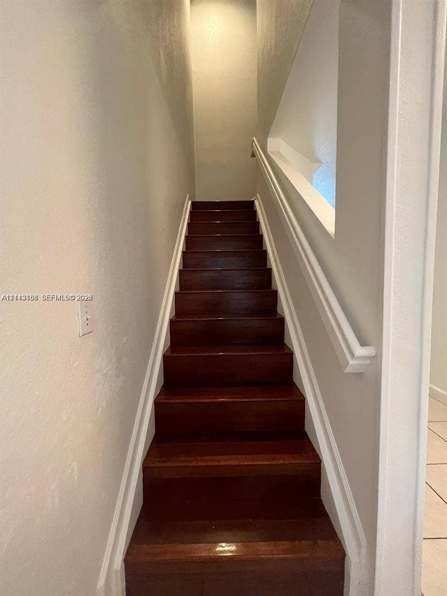 8706 NW 38th Drive, #2, Coral Springs, Coral Springs, FL 33065 Staircase featuring wood-finish treads and a white painted handrail