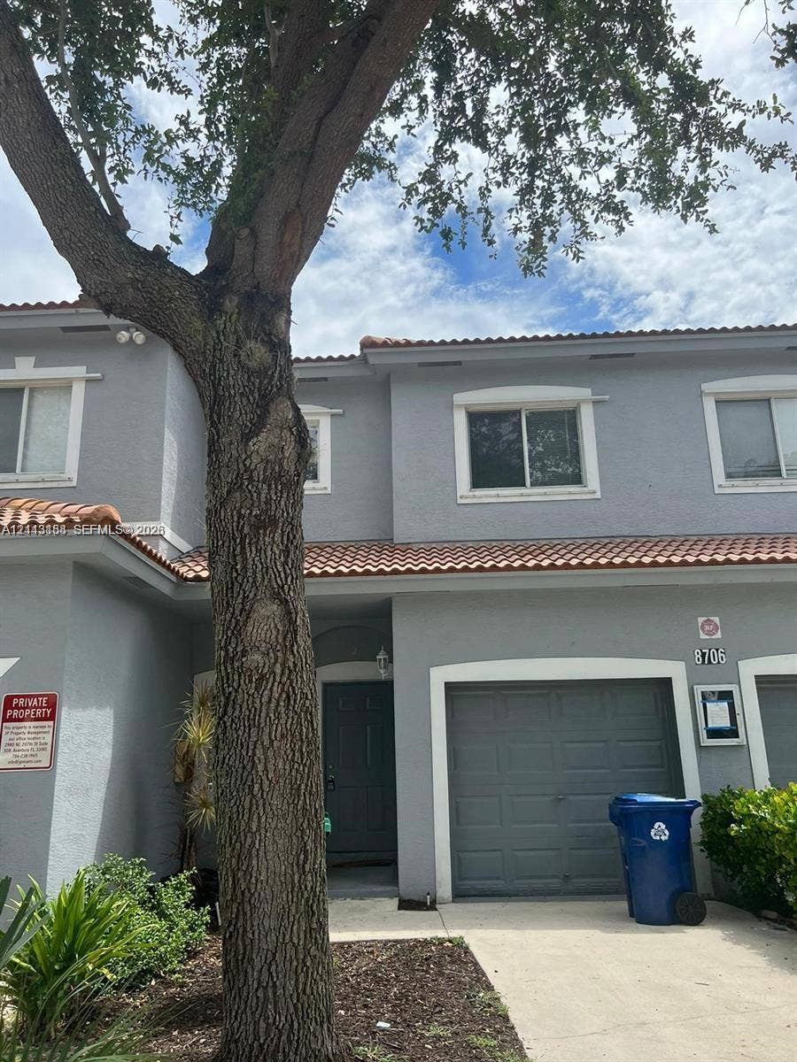 8706 NW 38th Drive, #2, Coral Springs, Coral Springs, FL 33065 Two-story residence featuring a gray stucco exterior, tile roofing, an attached single-car garage, and concrete driveway