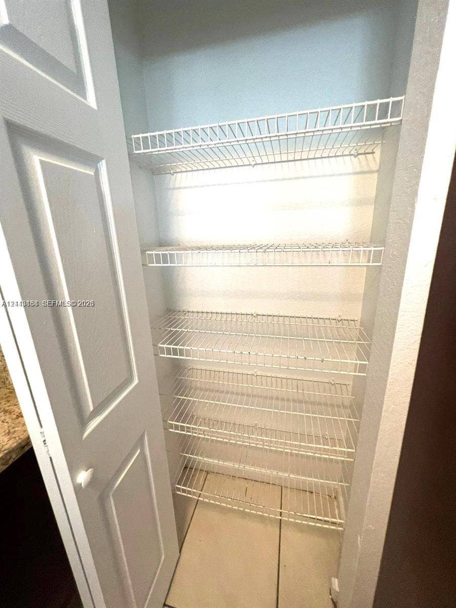 8706 NW 38th Drive, #2, Coral Springs, Coral Springs, FL 33065 Storage closet featuring five tiered wire shelves and a painted paneled door