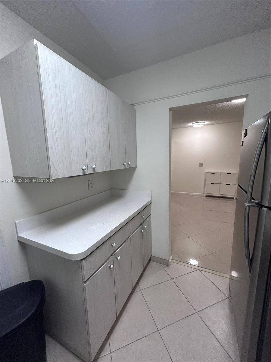 5700 NE 22nd Way, #324, Fort Lauderdale, Fort Lauderdale, FL 33308 Light-toned wood-finish cabinetry, solid-surface countertops, and diagonal-pattern tile flooring