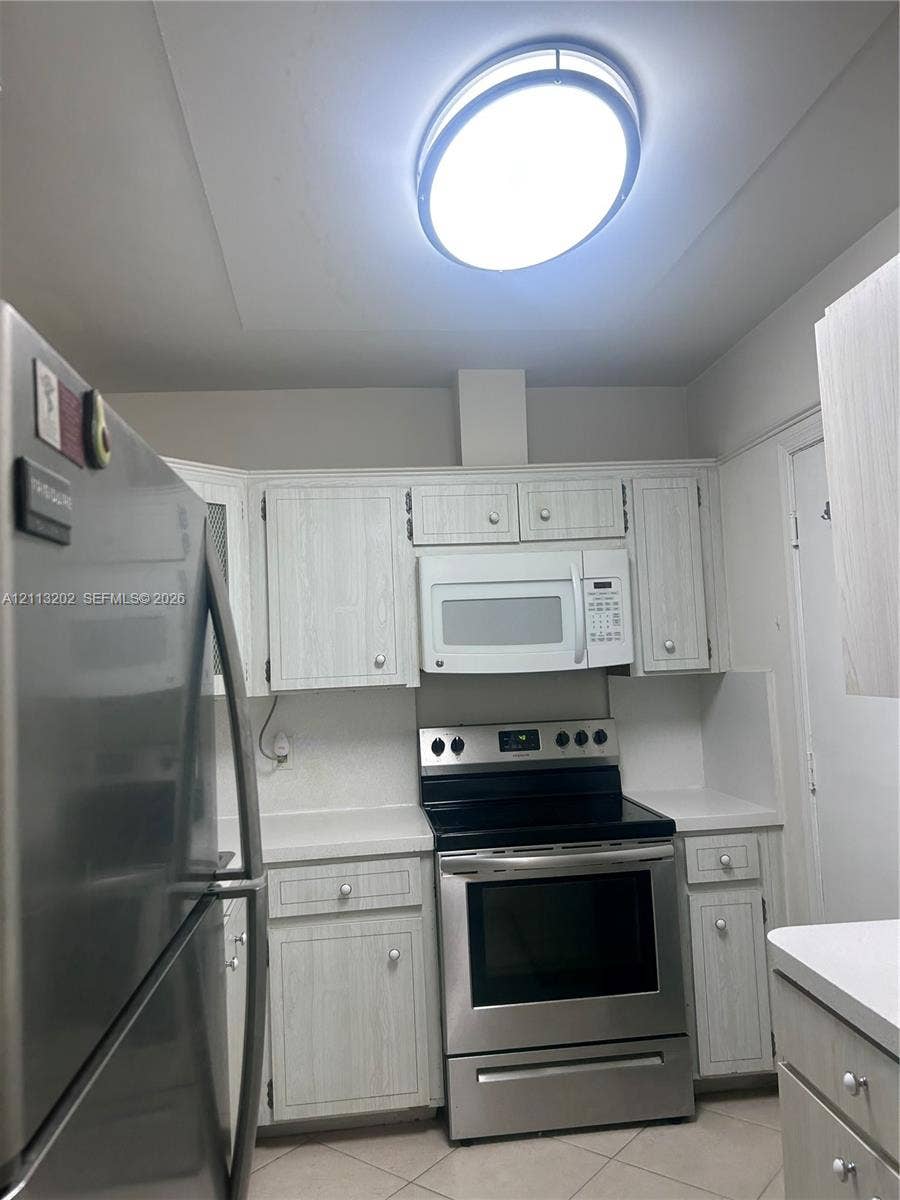 5700 NE 22nd Way, #324, Fort Lauderdale, Fort Lauderdale, FL 33308 Kitchen featuring light-finish cabinetry, stainless steel refrigerator and range, over-the-range microwave, and overhead flush-mount lighting