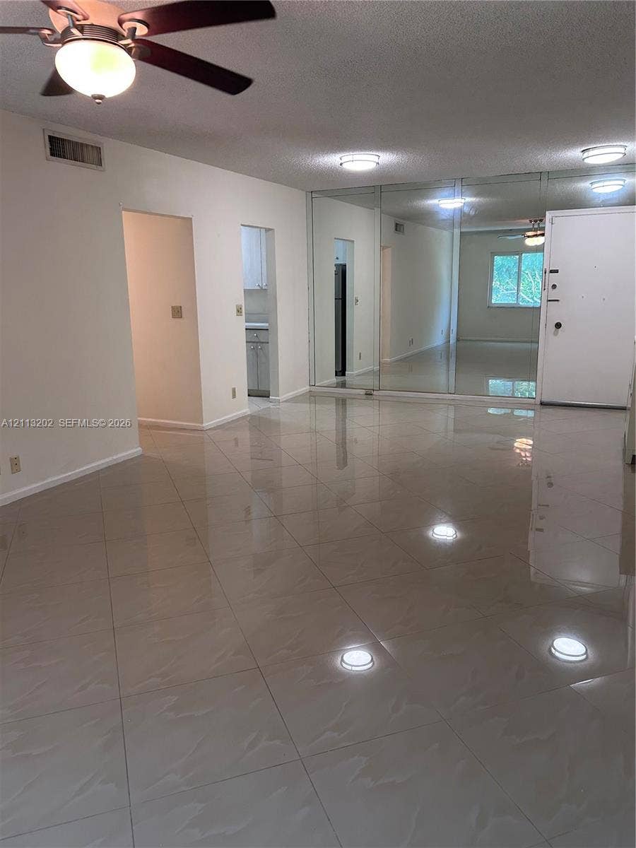 5700 NE 22nd Way, #324, Fort Lauderdale, Fort Lauderdale, FL 33308 Large-format tile flooring, mirrored wall panels, and ceiling fan with integrated lighting