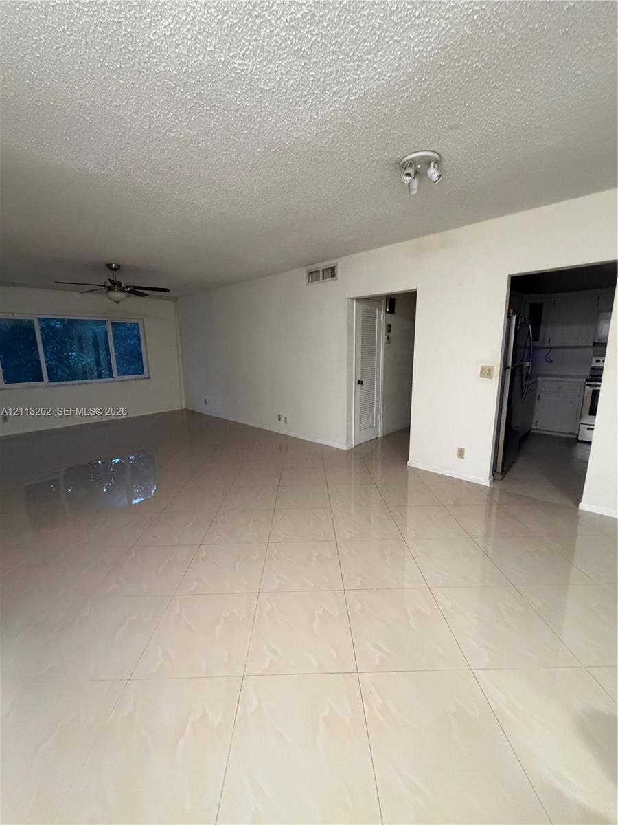5700 NE 22nd Way, #324, Fort Lauderdale, Fort Lauderdale, FL 33308 Large-format tile flooring, ceiling-mounted fan, multiple overhead light fixtures, and a dual-pane window