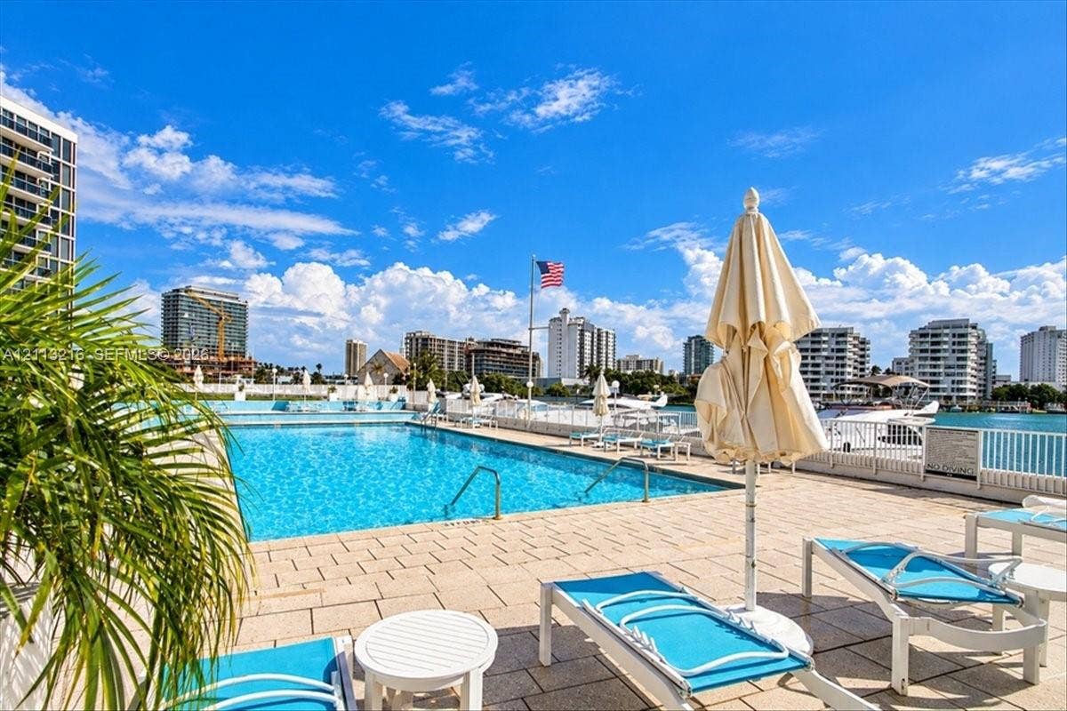 900 Bay Drive, #425, Miami Beach, FL 33141 In-ground swimming pool featuring a paved pool deck, metal safety fencing, and direct water frontage