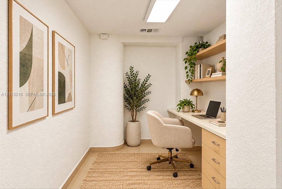 900 Bay Drive, #425, Miami Beach, FL 33141 Built-in wooden desk featuring a seamless countertop and integrated storage cabinetry, complemented by tiered floating wood shelving and smooth-finish walls
