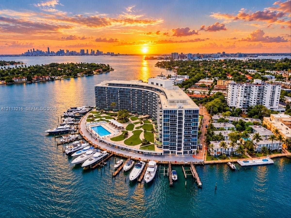 900 Bay Drive, #425, Miami Beach, FL 33141 Waterfront property featuring a multi-slip private marina, expansive outdoor swimming pool, landscaped grounds, and curvilinear architectural design