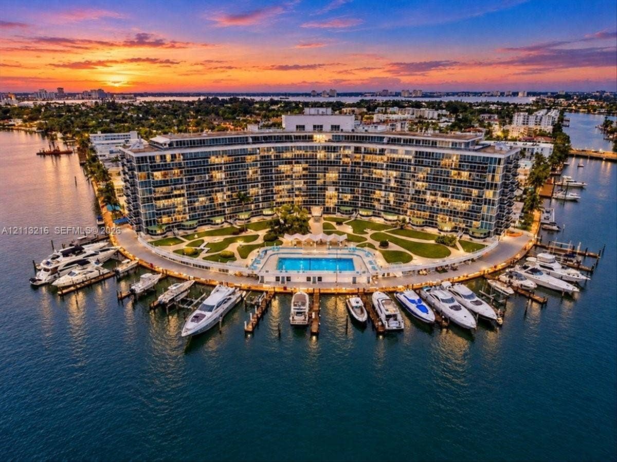900 Bay Drive, #425, Miami Beach, FL 33141 Waterfront multi-story residential structure featuring a private marina, paved boat slips, a perimeter swimming pool, and expansive manicured grounds