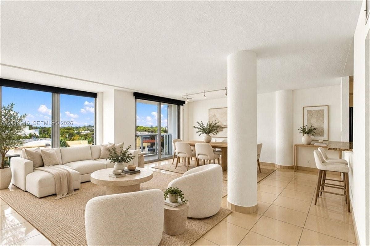 900 Bay Drive, #425, Miami Beach, FL 33141 Open-concept floor plan featuring large floor-to-ceiling windows, ceramic tile flooring, architectural structural columns, and recessed track lighting