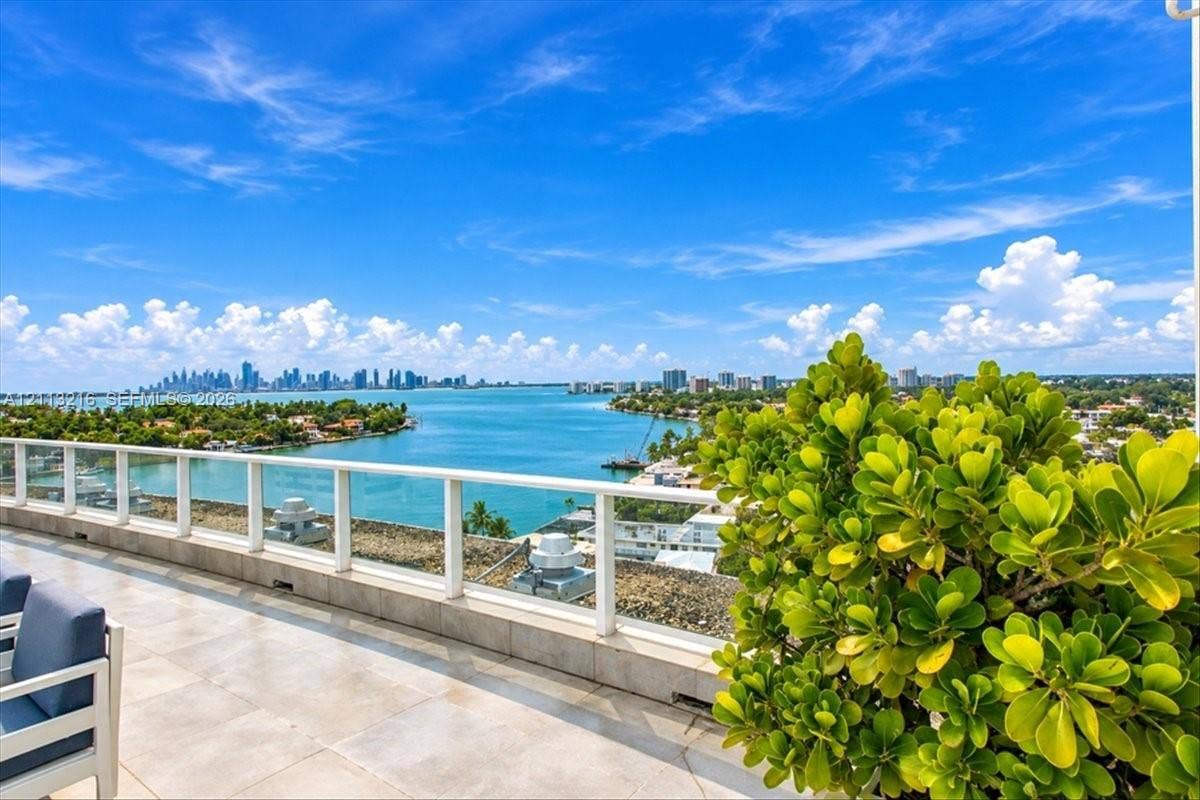 900 Bay Drive, #425, Miami Beach, FL 33141 Expansive terrace featuring light-toned tile flooring, glass panel railings, and a wide-reaching water and cityscape backdrop