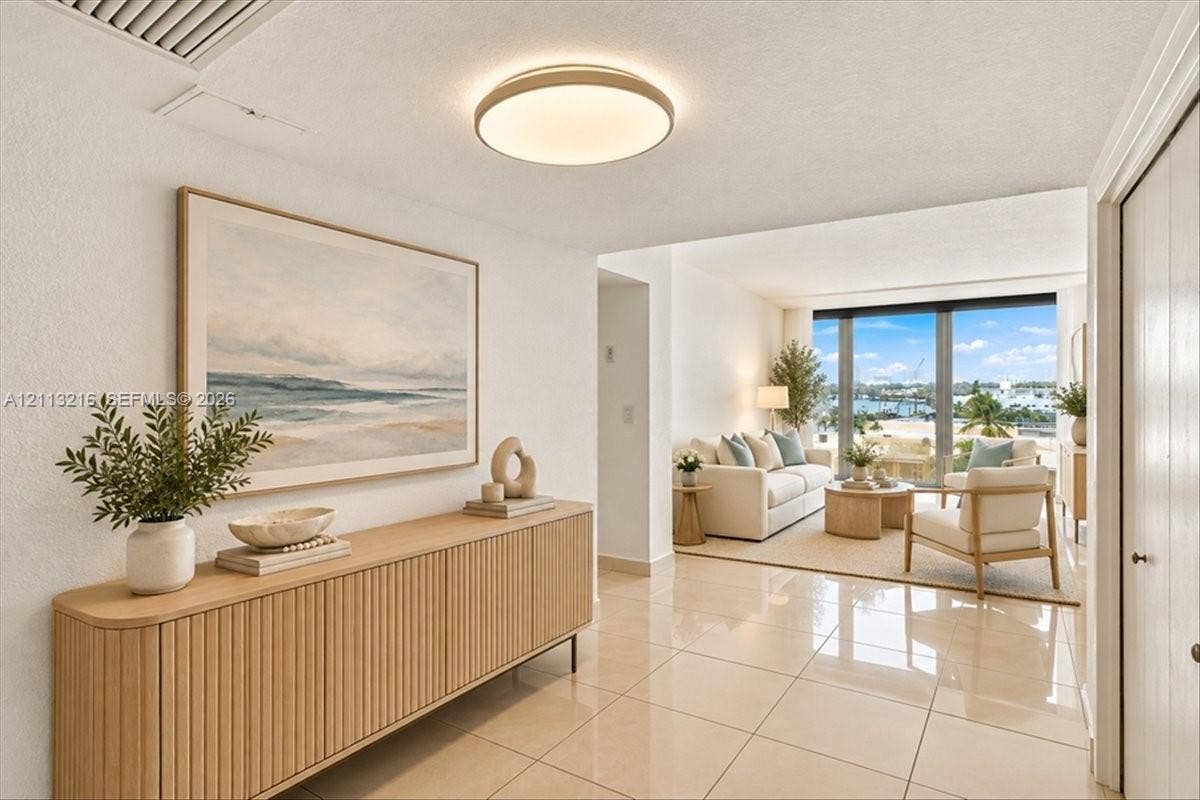900 Bay Drive, #425, Miami Beach, FL 33141 Polished stone tile flooring, neutral wall tones, low-profile circular LED flush-mount lighting, and floor-to-ceiling glass panel windows