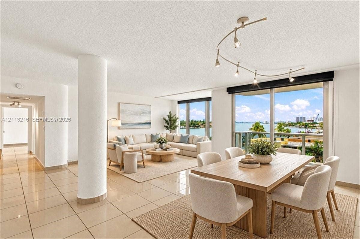 900 Bay Drive, #425, Miami Beach, FL 33141 Open floor plan featuring tile flooring, structural pillar, adjustable multi-head track lighting, and floor-to-ceiling glass sliding doors with water scenery