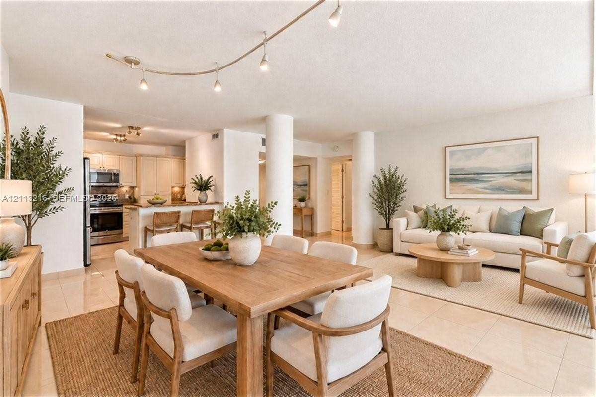 900 Bay Drive, #425, Miami Beach, FL 33141 Open-concept living space featuring high-gloss tile flooring, structural architectural columns, adjustable track lighting, and a breakfast bar