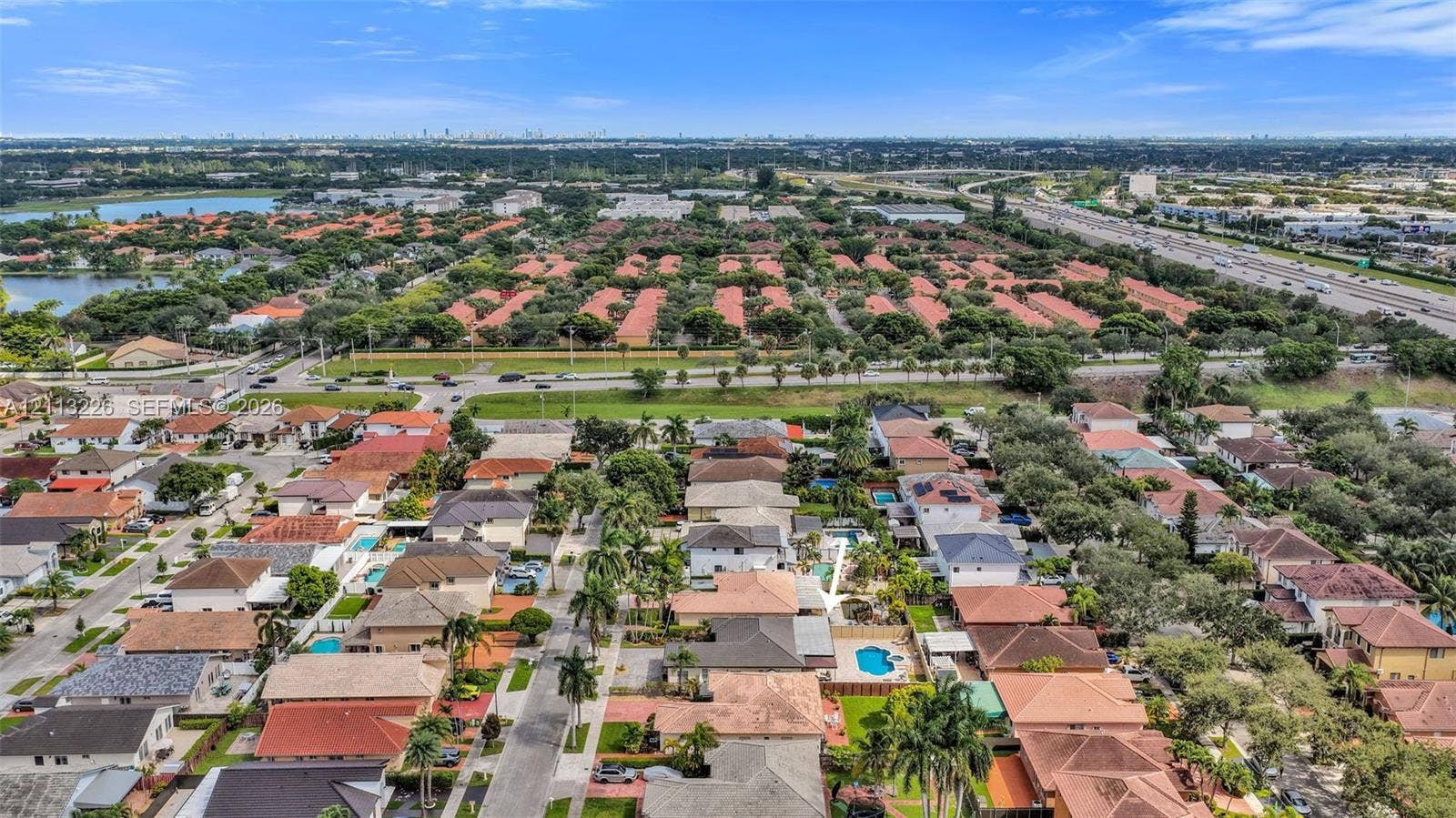 Aerial view showcasing a residential property featuring a backyard swimming pool and a tile roof