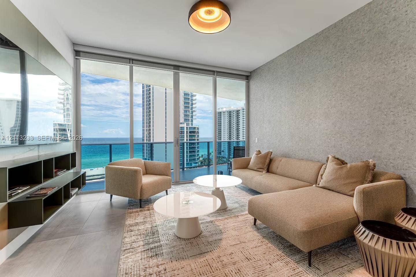 Floor-to-ceiling windows, built-in shelving, textured wall finish, tile flooring, and a glass-railing balcony