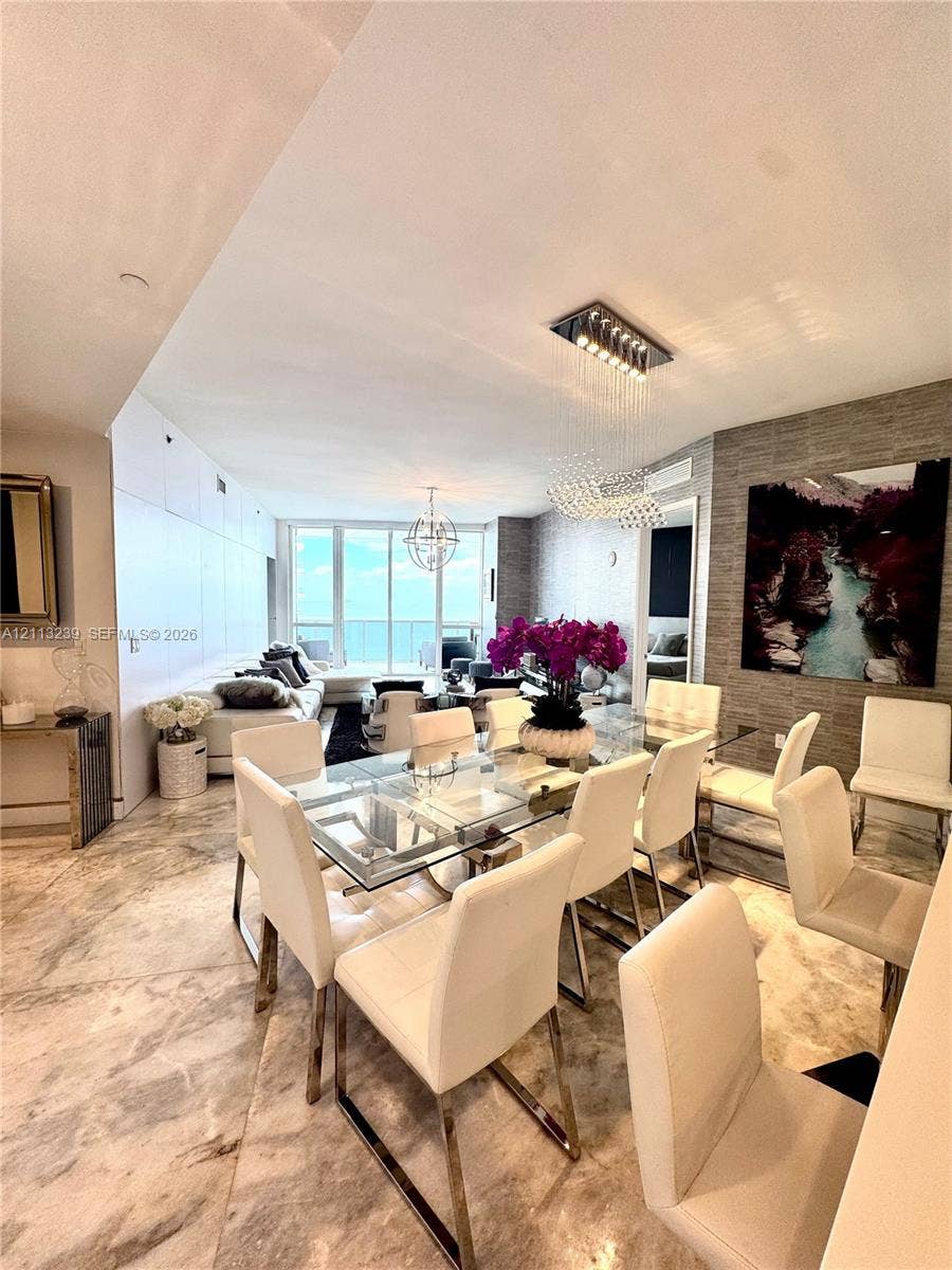 16001 Collins Avenue, #2403, Sunny Isles Beach, Sunny Isles Beach, FL 33160 Polished stone flooring, textured stone accent wall, floor-to-ceiling glass paneling, and custom integrated lighting fixtures