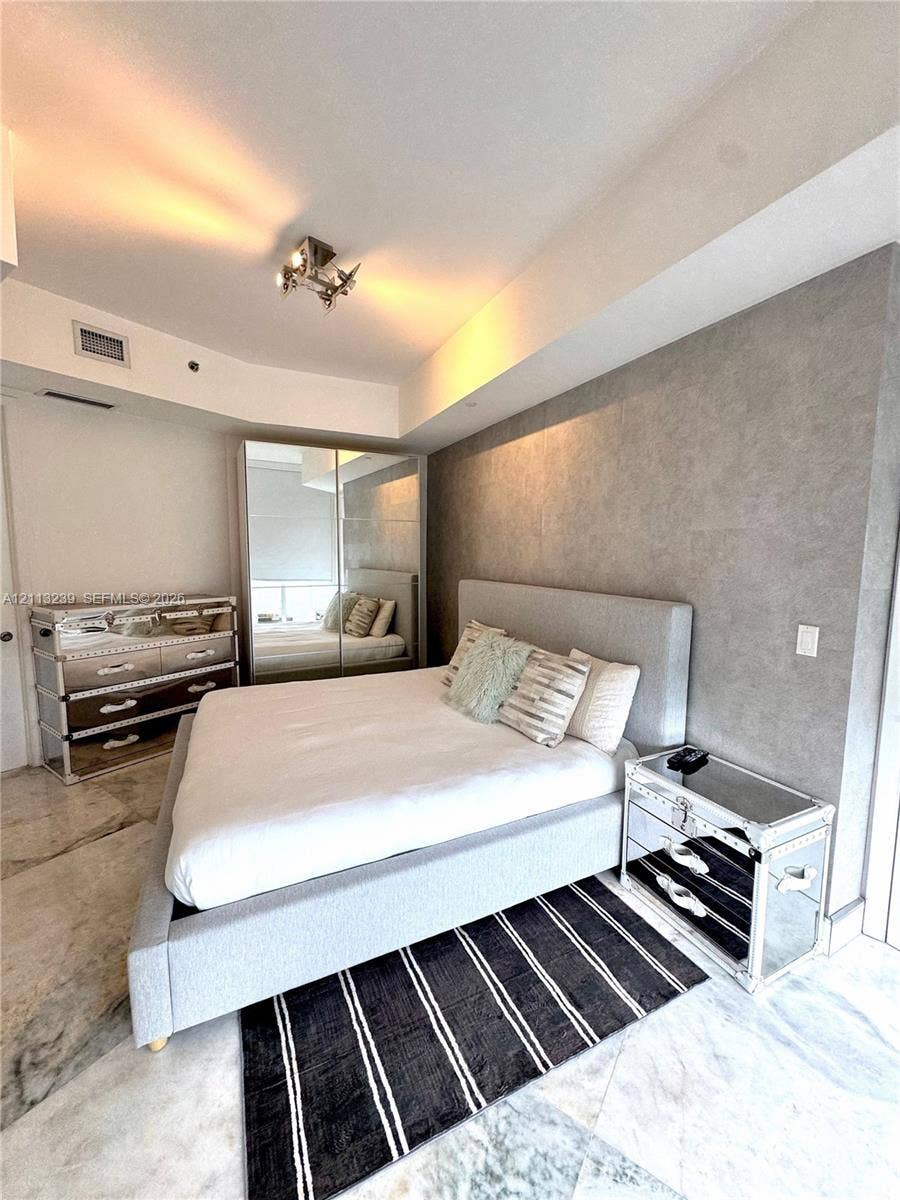 16001 Collins Avenue, #2403, Sunny Isles Beach, Sunny Isles Beach, FL 33160 Textured grey feature wall with stone-finish flooring and floor-to-ceiling mirrored closet doors