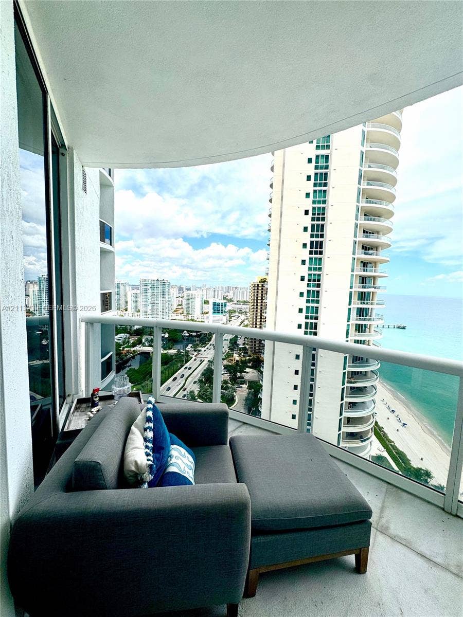 16001 Collins Avenue, #2403, Sunny Isles Beach, Sunny Isles Beach, FL 33160 Curved private balcony featuring a glass panel railing and tile flooring