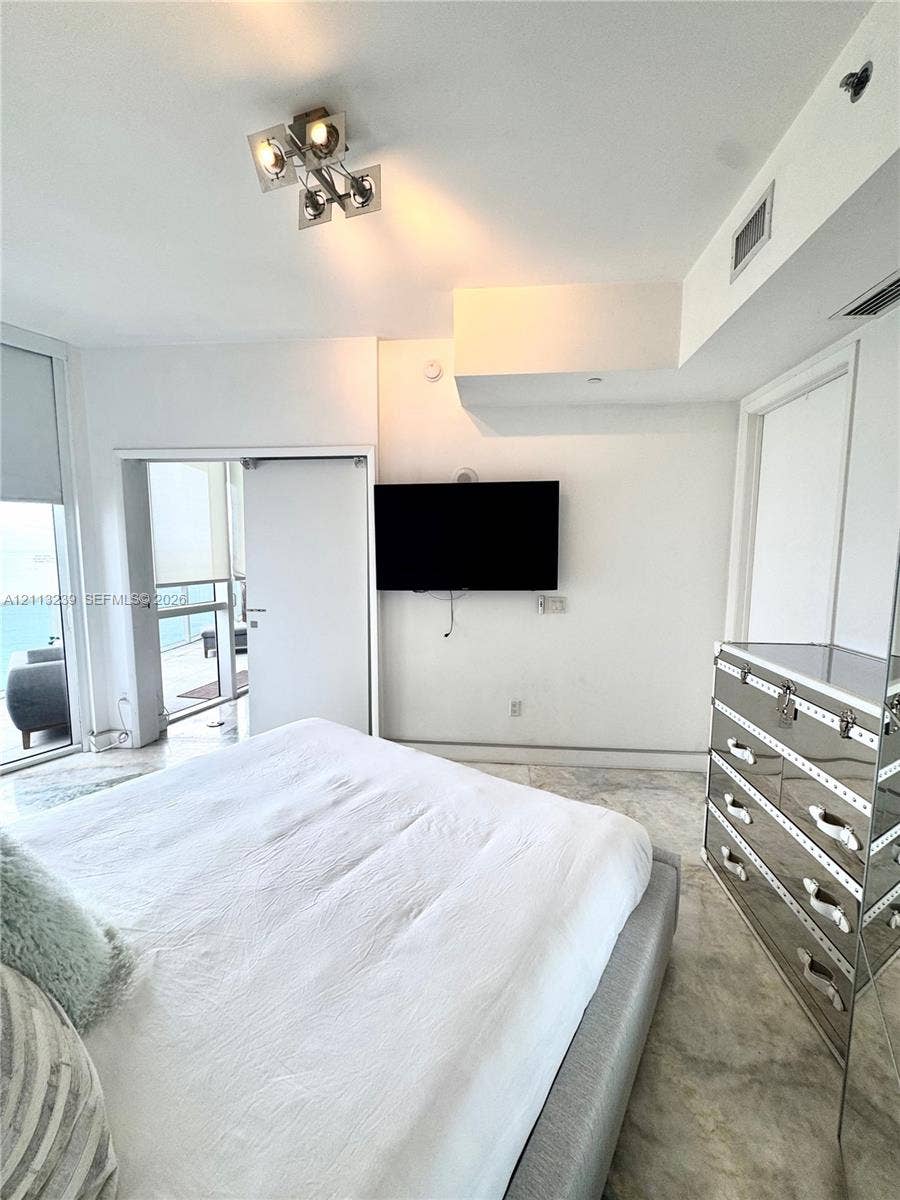 16001 Collins Avenue, #2403, Sunny Isles Beach, Sunny Isles Beach, FL 33160 Interior space featuring stone-finish flooring, floor-to-ceiling glass door, and a modern multi-light square ceiling fixture