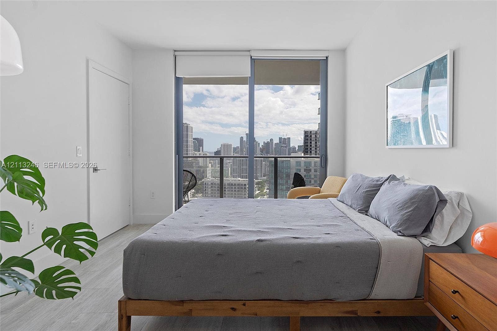121 NE 34th Street, #2703, Miami, FL 33137 Floor-to-ceiling sliding glass door, private balcony, and light wood-finish flooring