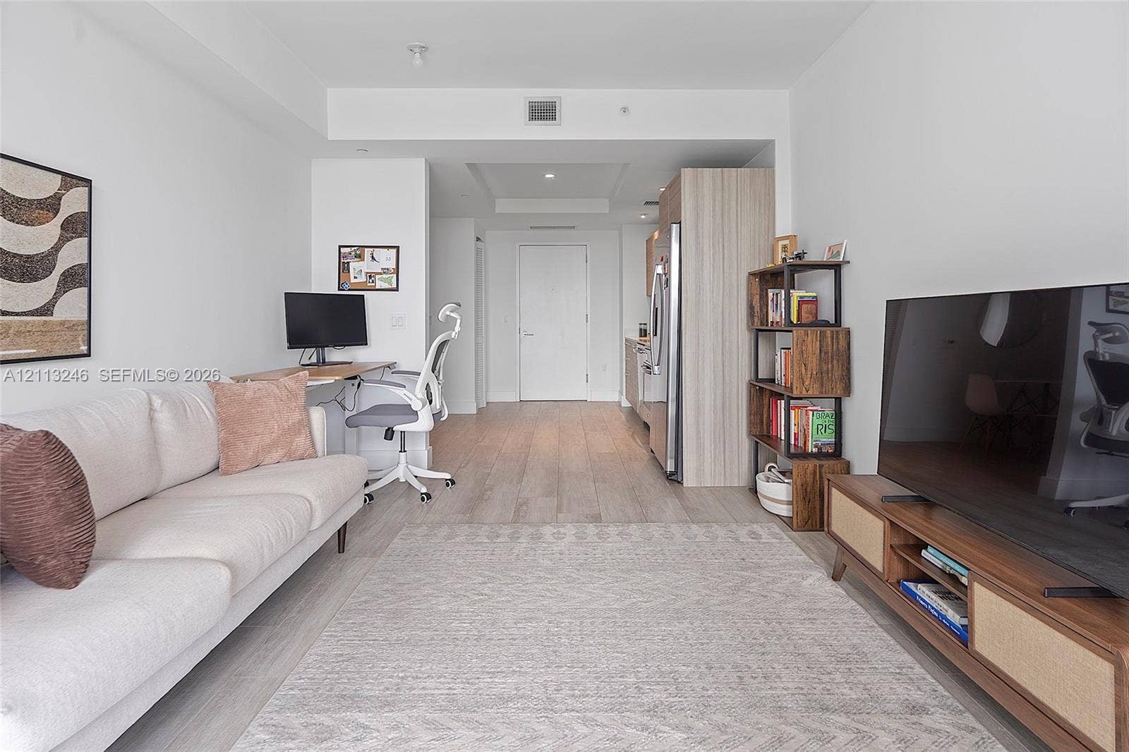 121 NE 34th Street, #2703, Miami, FL 33137 Open-concept interior featuring wood-finish flooring, neutral walls, recessed lighting, and built-in cabinetry with a light wood finish