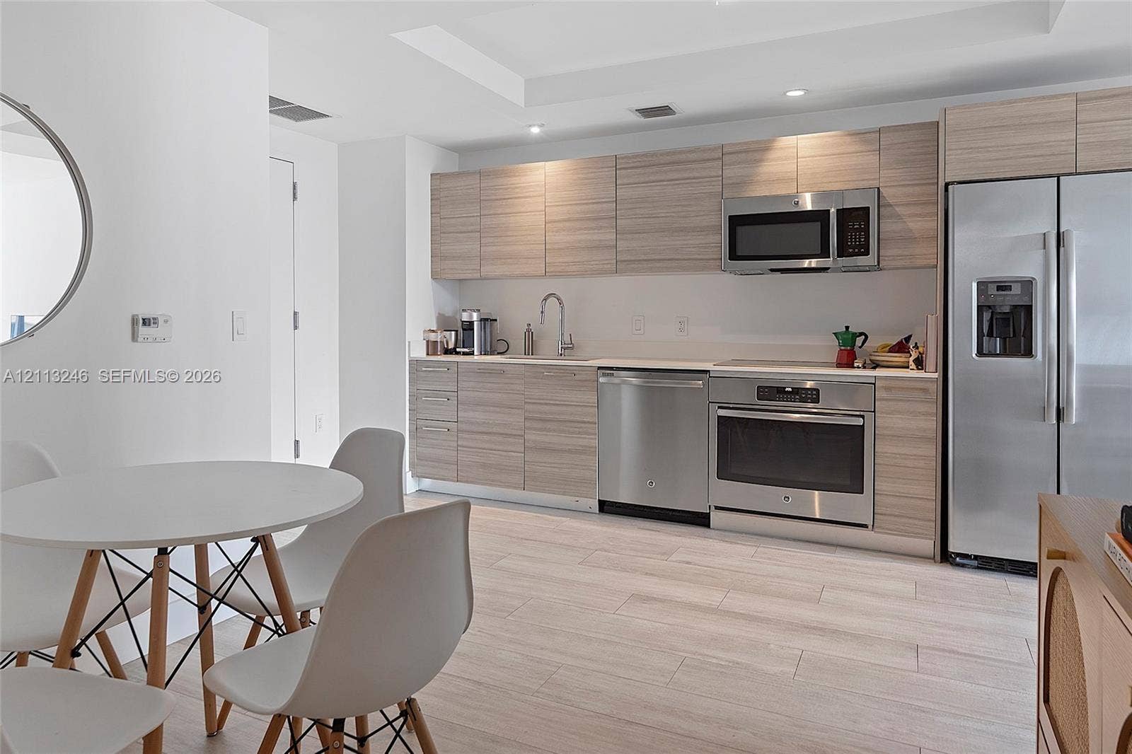 121 NE 34th Street, #2703, Miami, FL 33137 Kitchen featuring wood-finish cabinetry, stainless steel appliances, light-toned tile flooring, and recessed ceiling lighting