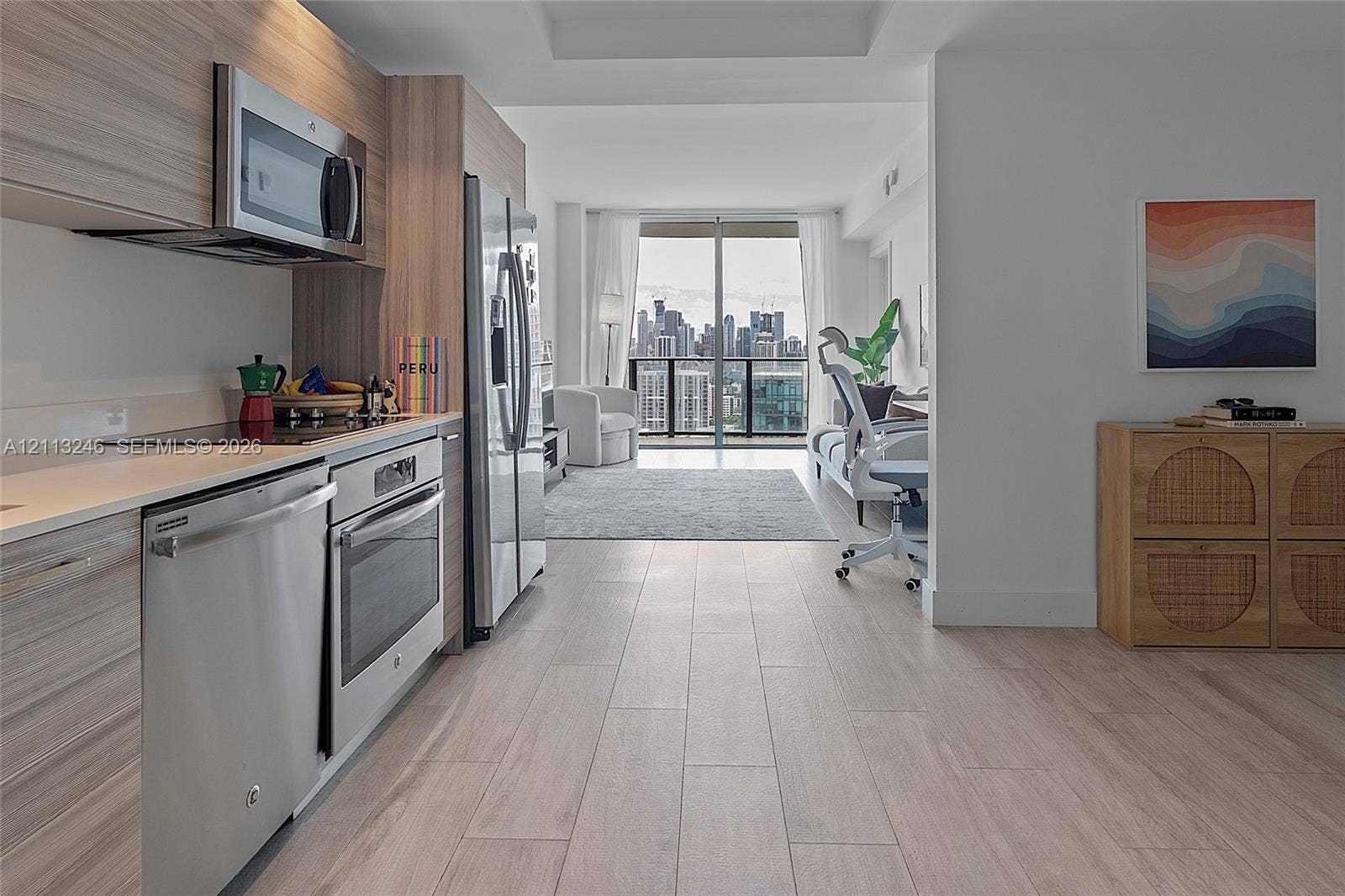 121 NE 34th Street, #2703, Miami, FL 33137 Kitchen featuring wood-finish cabinetry, stainless steel appliances, solid-surface countertops, and wood-finish flooring