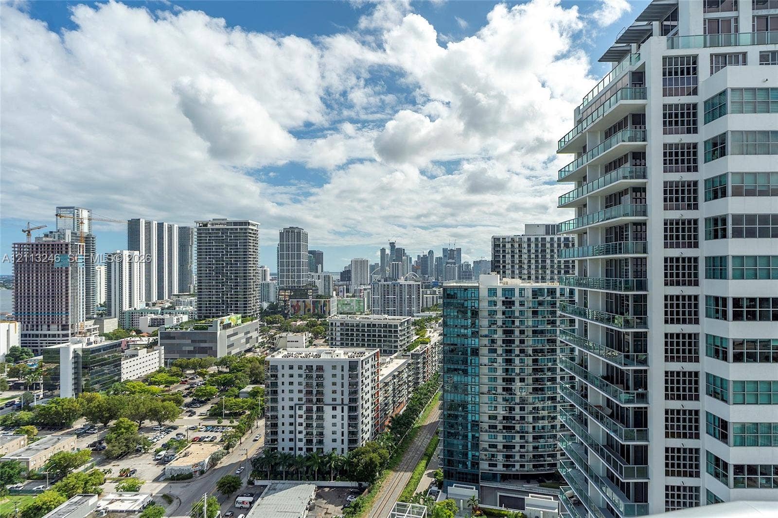 121 NE 34th Street, #2703, Miami, FL 33137 High-rise exterior featuring wraparound balconies with glass railings and white concrete structural facade