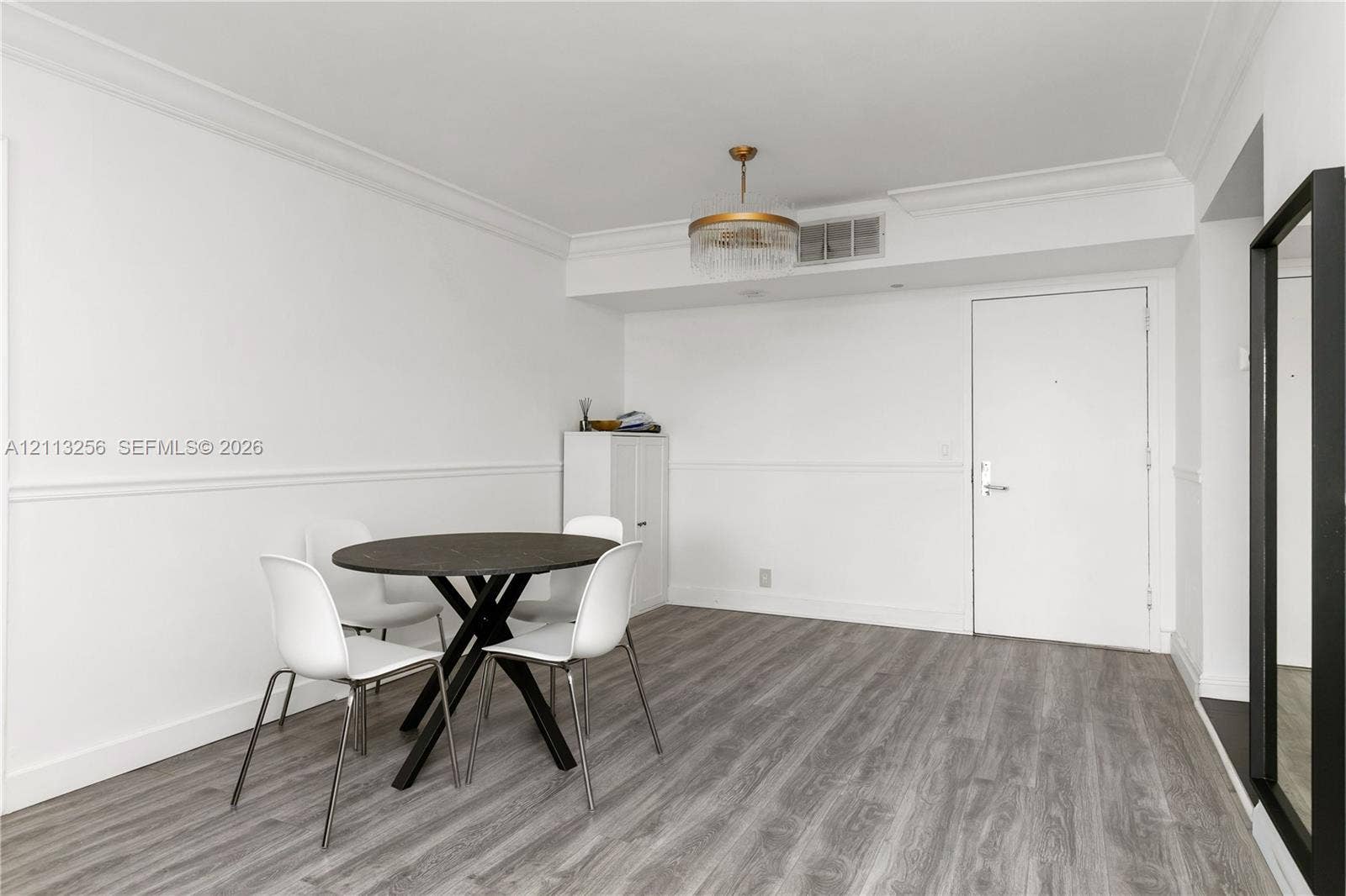 3300 NE 191st Street, #1514, Aventura, FL 33180 Wood-finish flooring, crown molding, chair rail trim, and a gold-tone drum chandelier