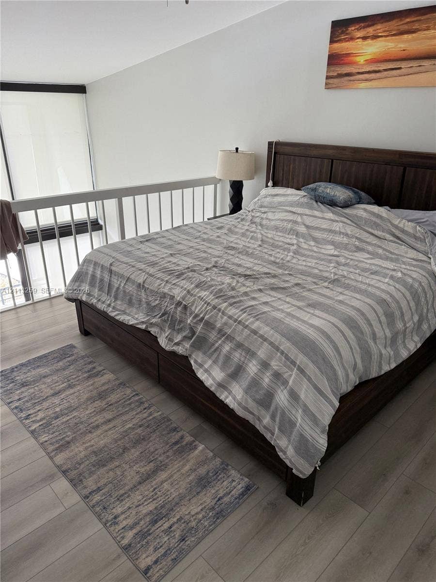 Wood-finish flooring, white railing enclosure, and floor-to-ceiling windows