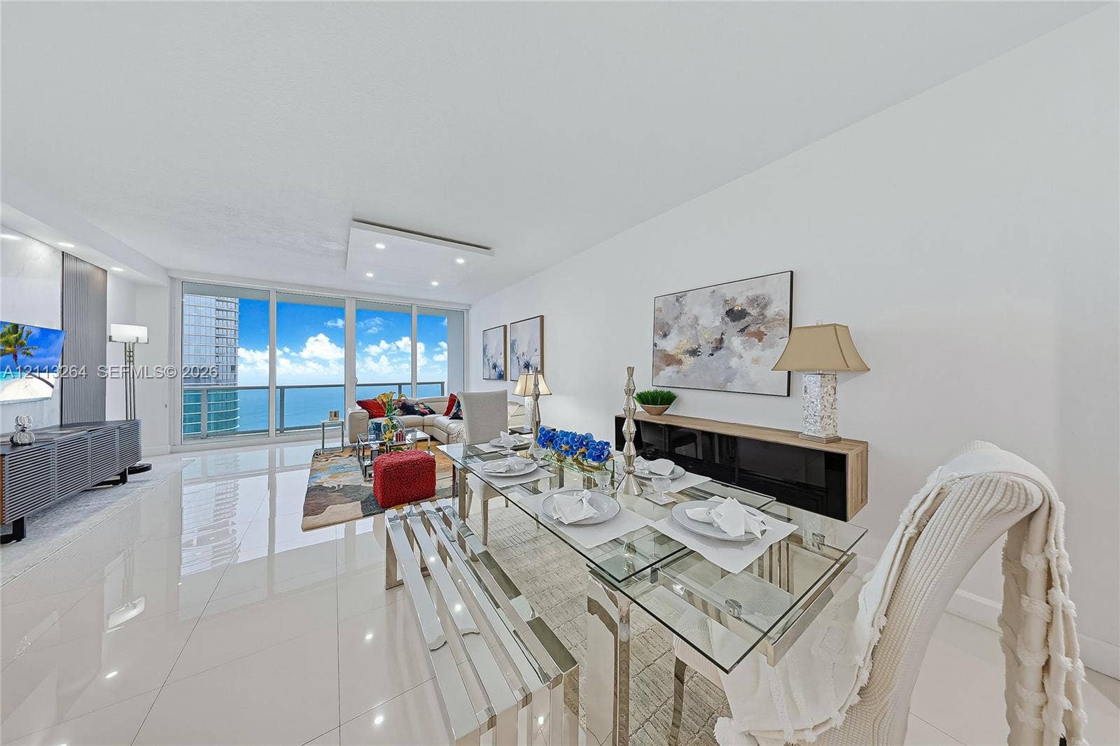 Open-concept interior featuring large-format tile flooring, recessed ceiling lighting, and floor-to-ceiling glass panel walls
