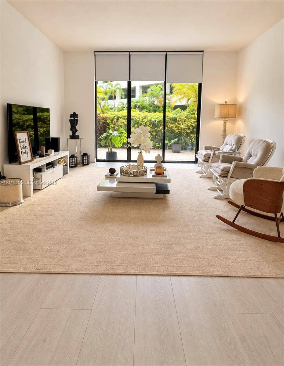 Floor-to-ceiling sliding glass door with sheer drapery and wood-finish flooring