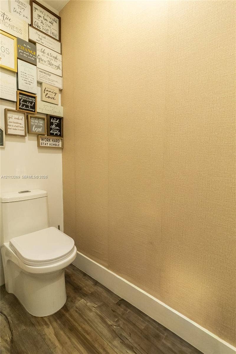 11494 NW 79th Lane, Doral, FL 33178 Powder room featuring a two-piece toilet, textured wall covering, and wood-finish flooring