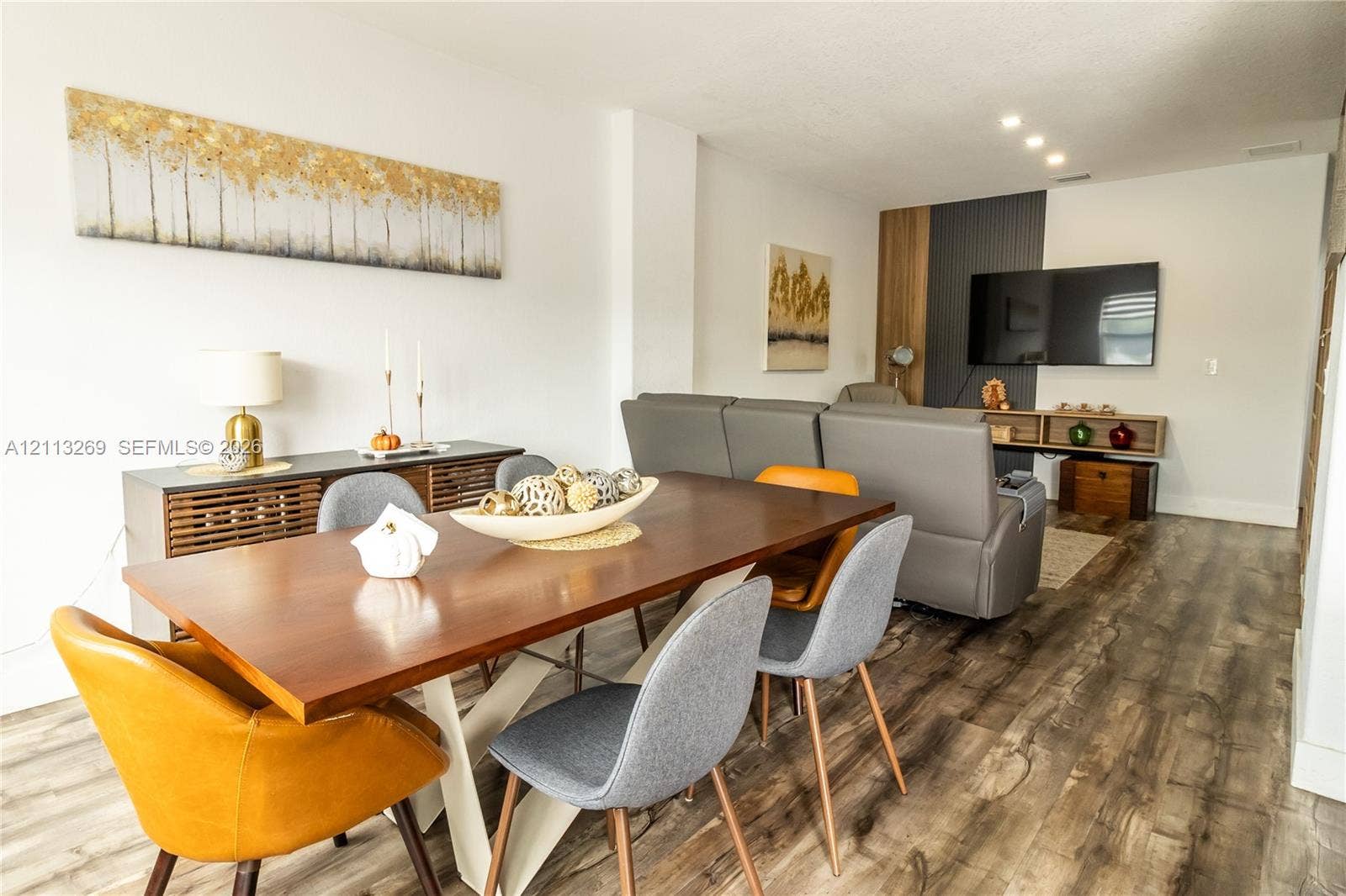 11494 NW 79th Lane, Doral, FL 33178 Wood-finish flooring, recessed lighting, and a vertical wood and charcoal paneled accent wall