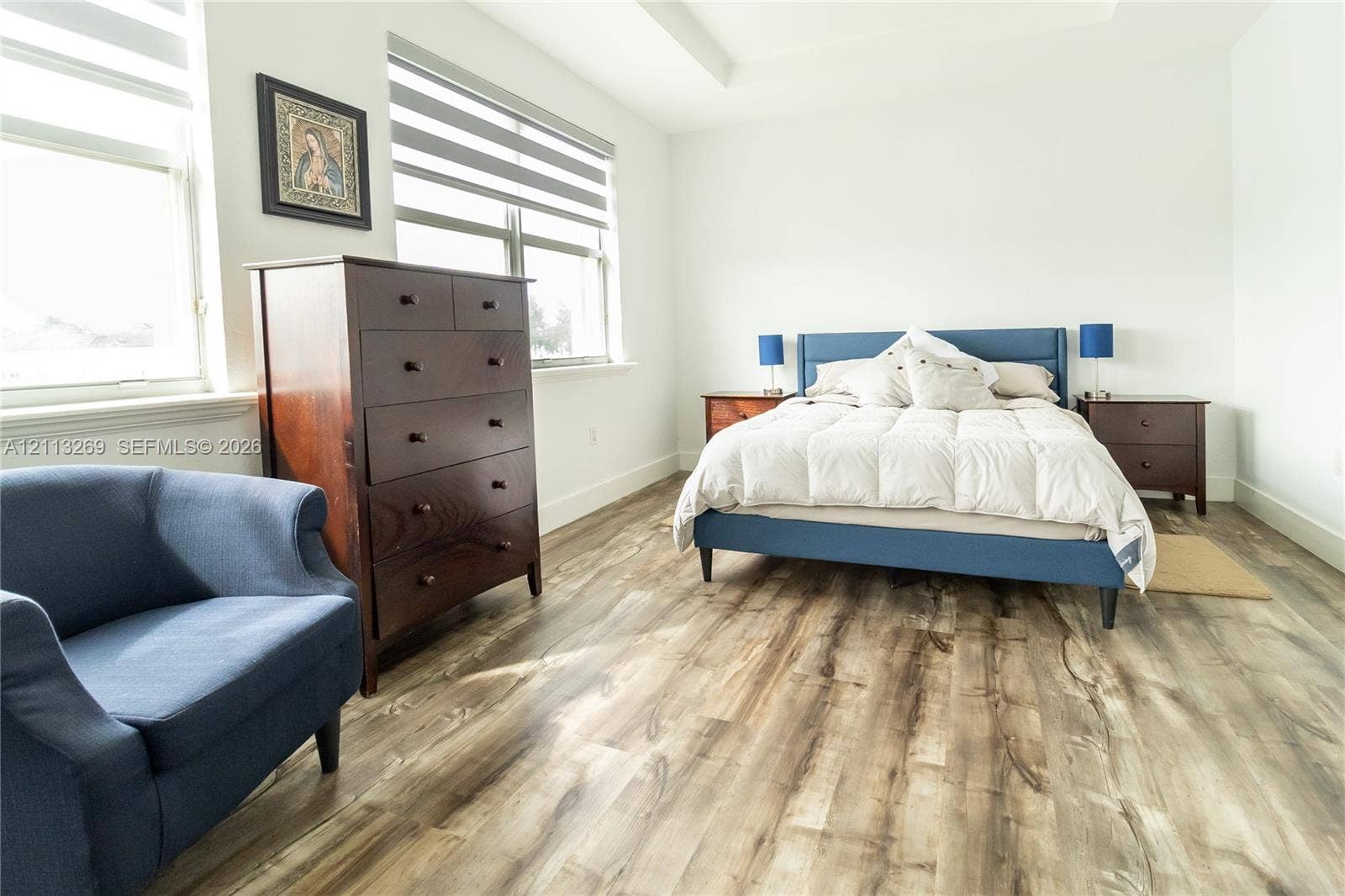 11494 NW 79th Lane, Doral, FL 33178 Bedroom featuring high ceilings, wood-finish flooring, and large windows with dual-layer adjustable blinds