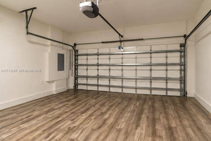 11494 NW 79th Lane, Doral, FL 33178 Enclosed garage featuring wood-finish flooring, a metal sectional door, and an overhead automatic opener
