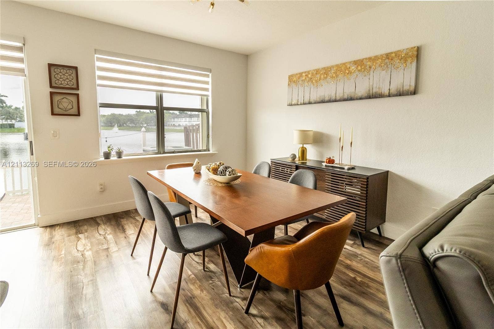 11494 NW 79th Lane, Doral, FL 33178 Wood-finish flooring, large window with horizontal blinds, glass sliding door, and neutral wall tones
