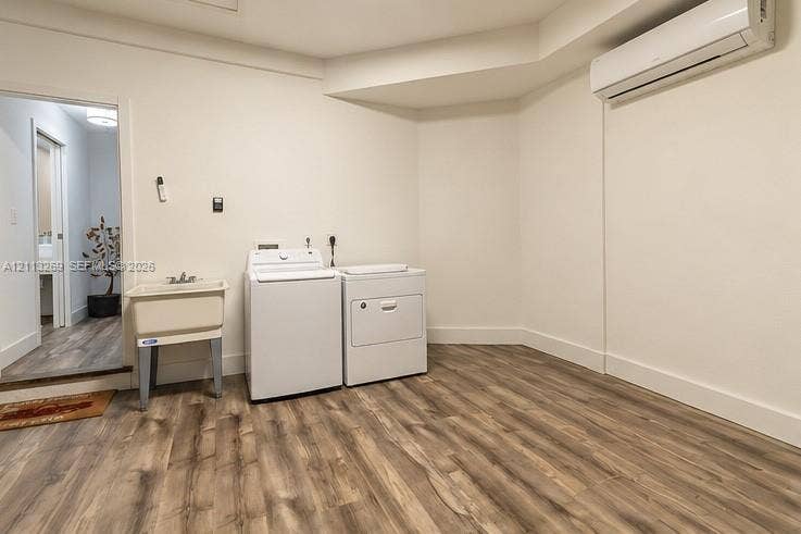 11494 NW 79th Lane, Doral, FL 33178 Utility space featuring wood-finish flooring, a wall-mounted ductless climate control unit, and a built-in utility sink