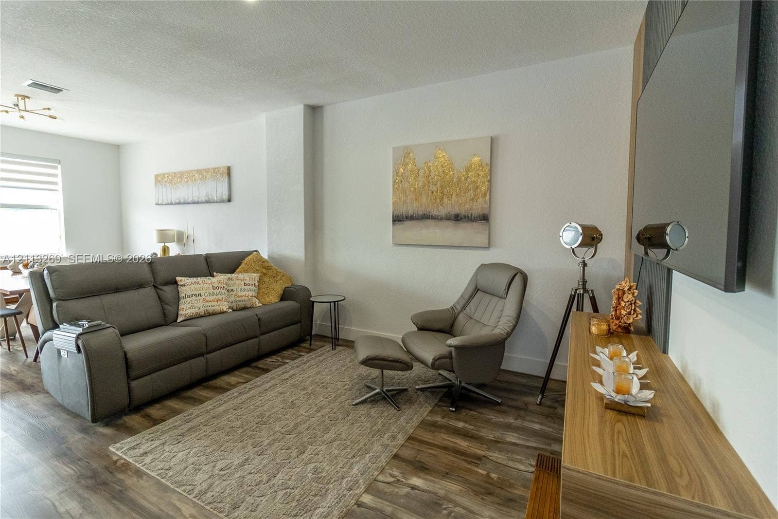11494 NW 79th Lane, Doral, FL 33178 Living area featuring wood-finish flooring, neutral walls, and a wall-mounted television installation
